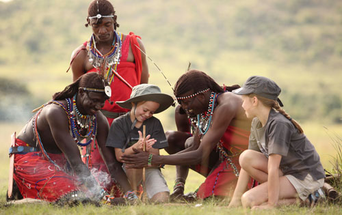 Masai warriors teaching kids how to start a fire