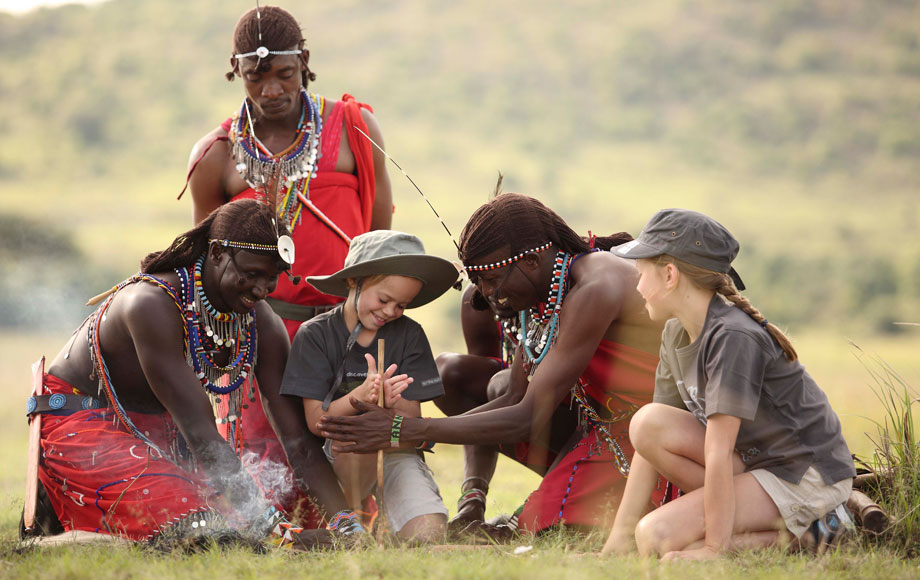 Masai warriors teaching kids how to start a fire