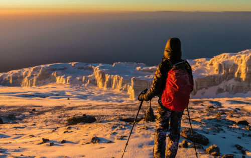 Trekker at the top of Mount Kilimanjaro